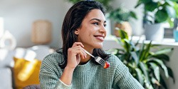 Woman smiling while eating healthy meal at home