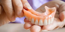 Upper denture held in hand