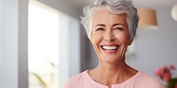 an older woman smiling with bright new dentures