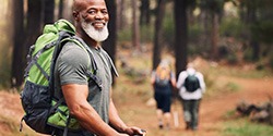 an older man smiling while on a hike