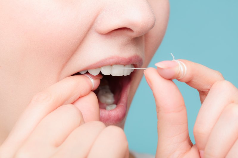 A closeup of a woman flossing